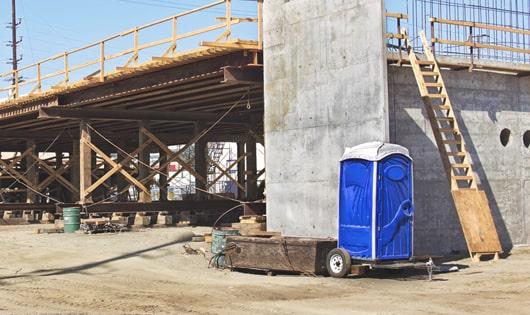 a row of blue porta potties set up on a construction site